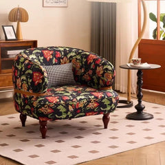 Floral-patterned armchair in a living room setting with a side table and lamp.