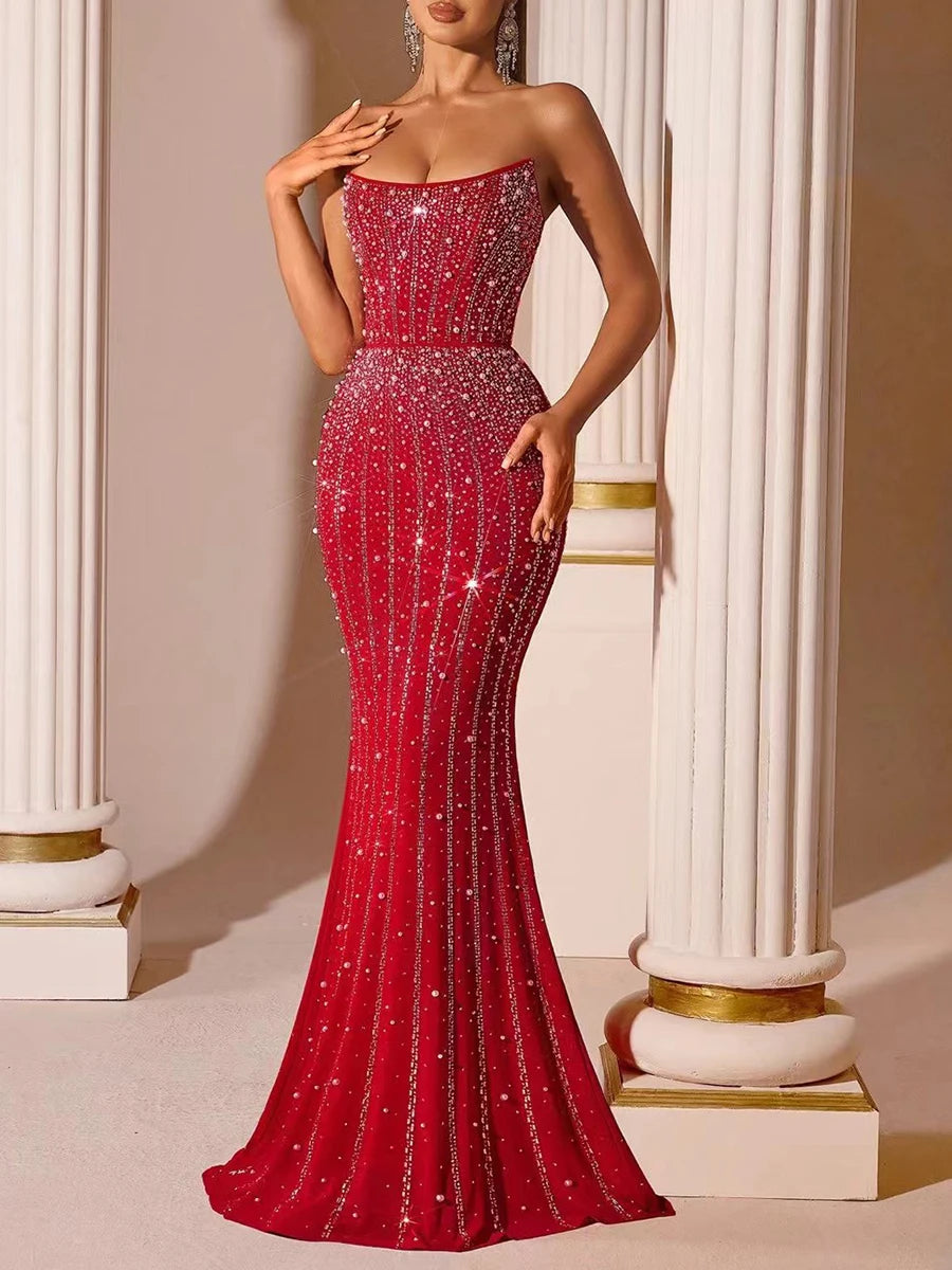 Red evening gown with sparkling details on a neutral background