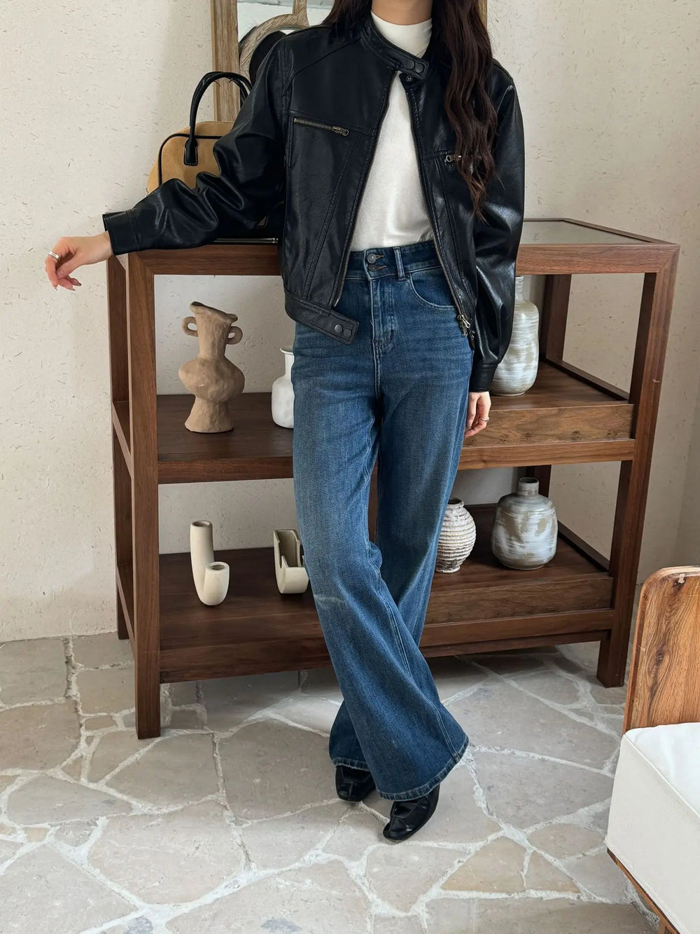 Black faux leather moto jacket with wide-leg jeans