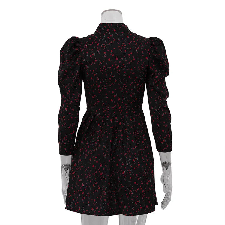 Black dress with red floral pattern on a mannequin against a white background
