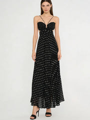 Model wearing black polka dot maxi dress with plunging neckline