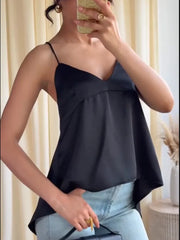 Person wearing a black top and light blue jeans indoors.