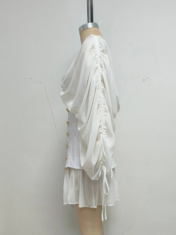 White dress with ruffled details on a mannequin against a plain background
