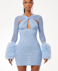 Woman wearing a light blue dress with feathered sleeves on a white background