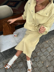 Close-up of yellow utility jacket and midi skirt set