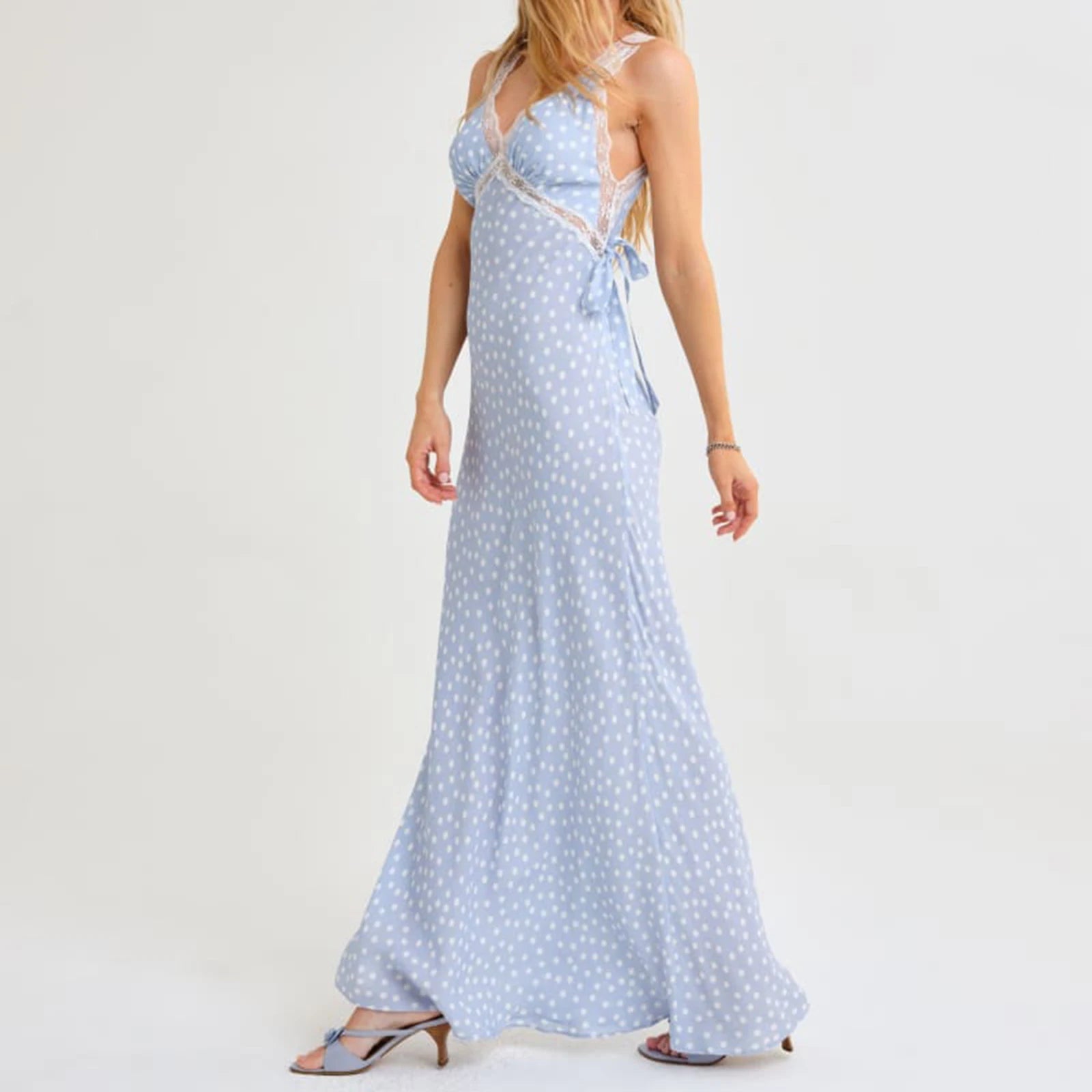 Woman wearing a light blue polka dot dress on a white background