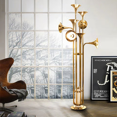 Art Deco trumpet floor lamp with a Nordic gold finish, illuminating a stylish living room. Golden Atelier 4