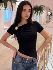Model indoors wearing black asymmetric neckline top and jeans