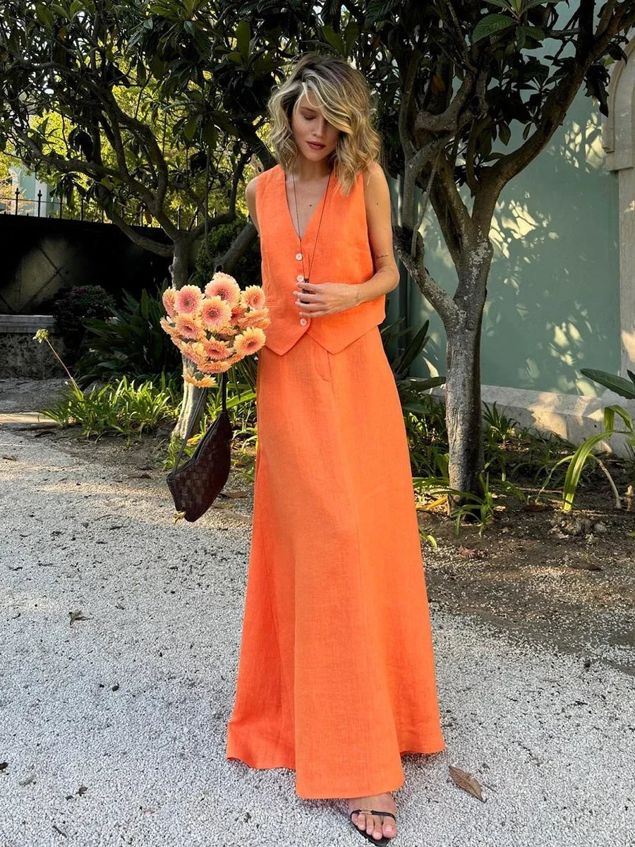 Woman in an orange dress holding flowers outdoors