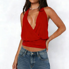 Woman wearing a red halter top and blue jeans on a white background