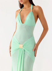 Mint green halter neck dress with a gold belt on a white background