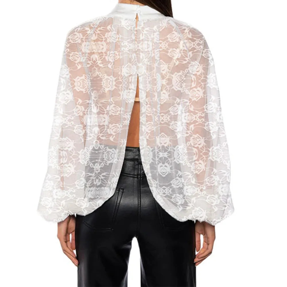 White lace top worn over a black leather outfit on a white background