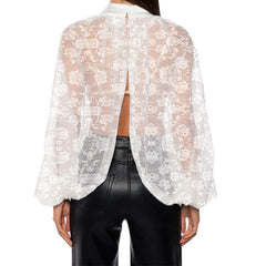 White lace top worn over a black leather outfit on a white background