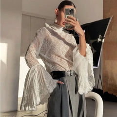 Person wearing a white lace top and gray pants taking a mirror selfie.