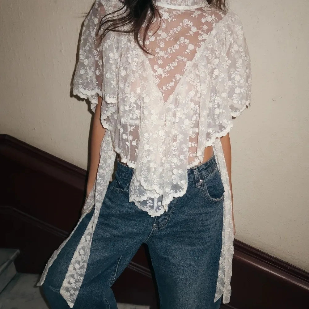 White floral lace mock neck top with ruffled asymmetrical hem and flutter sleeves