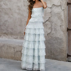 Woman wearing a light blue lace dress against a textured wall.