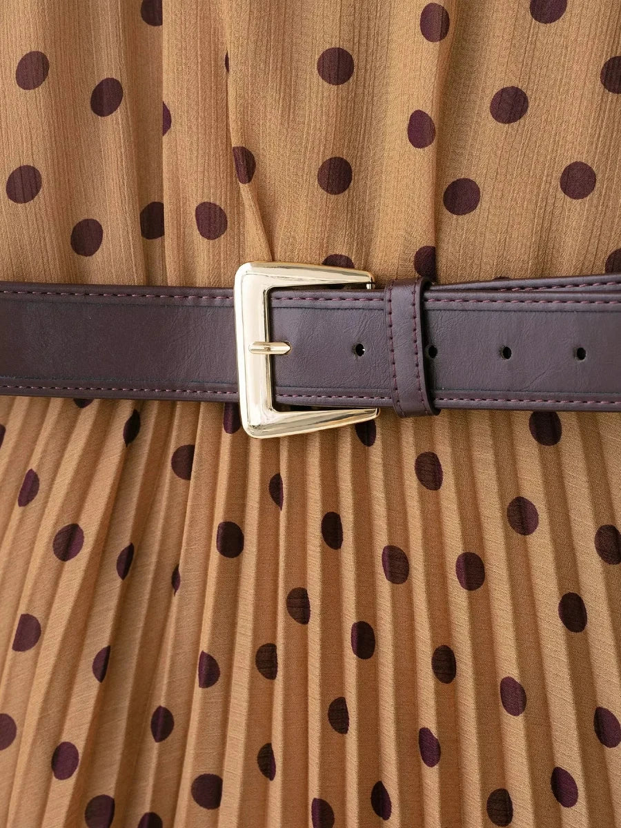 Close-up of a polka dot dress with a belt and gold buckle.