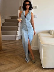 Woman in a light blue denim dress standing in a modern interior setting.