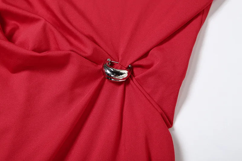 Close-up of a red fabric with a silver brooch on a white background