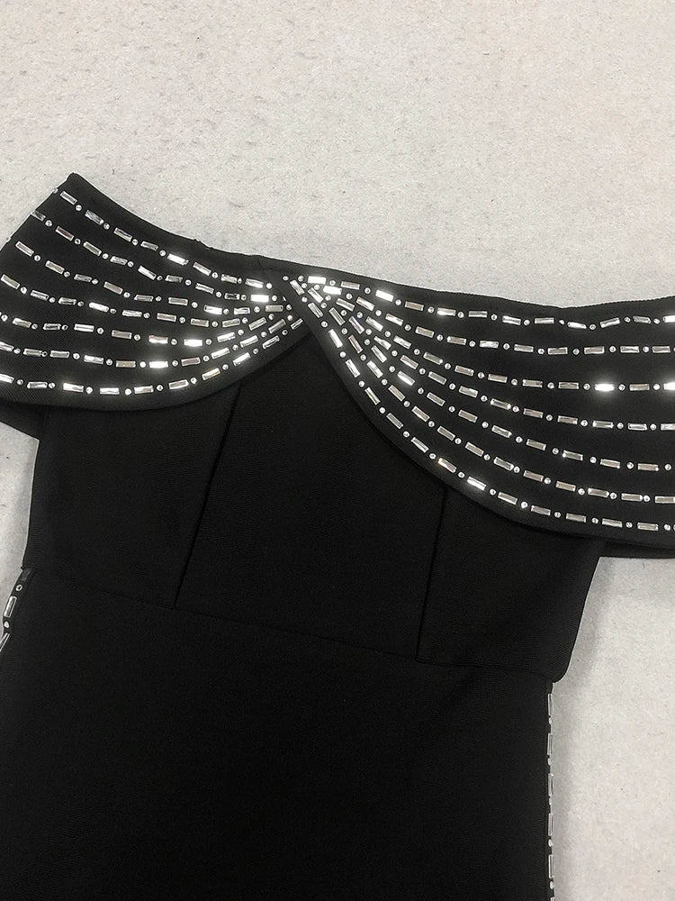 Black dress with reflective silver details on a light gray background