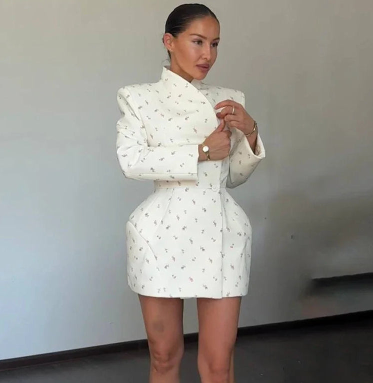 Woman wearing a white patterned outfit against a plain background