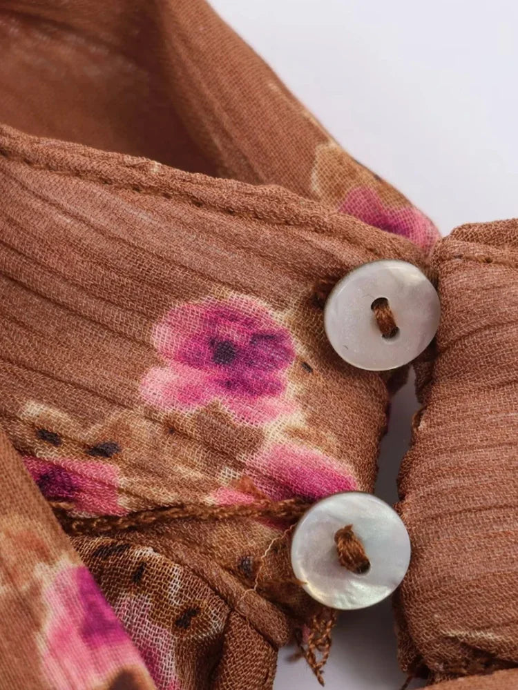 Close-up of a brown fabric with floral patterns and white buttons.
