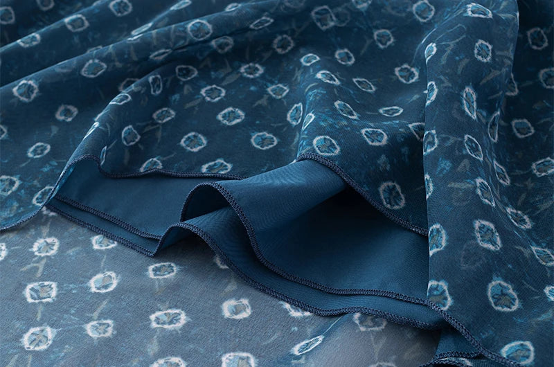 Detail of the chiffon fabric and layered hem on a geometric print mini dress