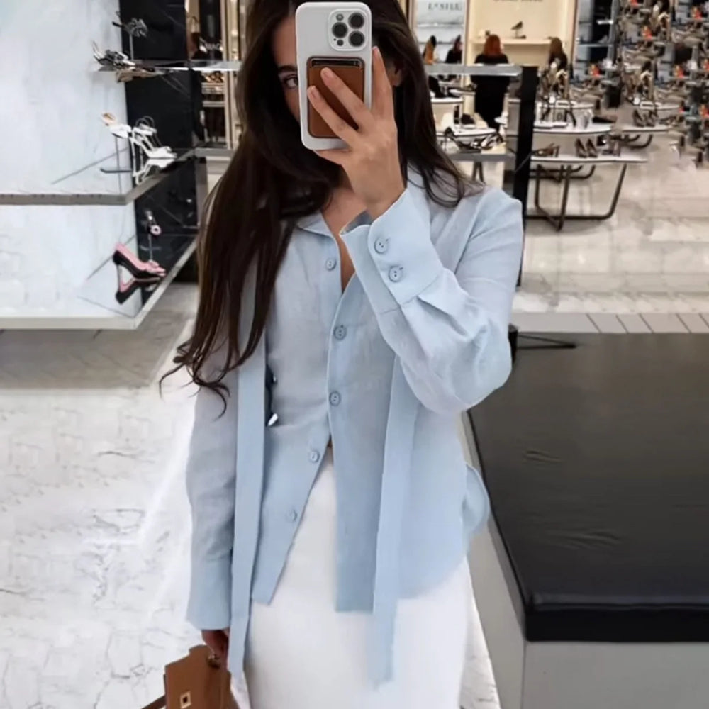 Person wearing a light blue shirt over a white dress in a store setting