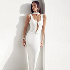 Woman wearing a white sleeveless jumpsuit with a deep neckline on a plain background