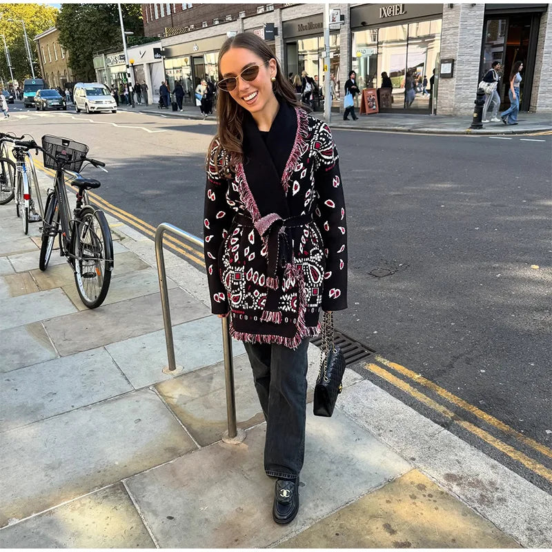 Woman in a patterned coat standing on a city street
