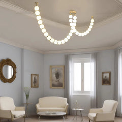 Sleek modern chandelier with LED lights, hanging above a lighting room table. . Golden Atelier 4