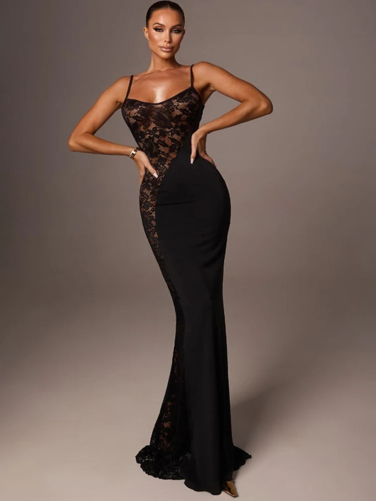 Woman wearing a black lace evening gown against a gray background