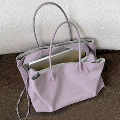 Lilac tote bag with grey lining and a laptop inside