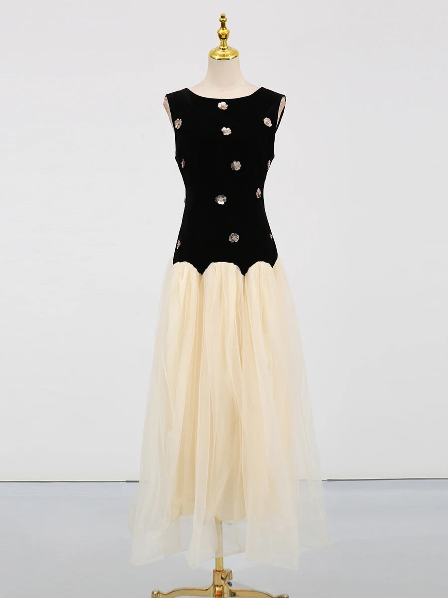 Black top with silver buttons and beige skirt on a mannequin against a white background