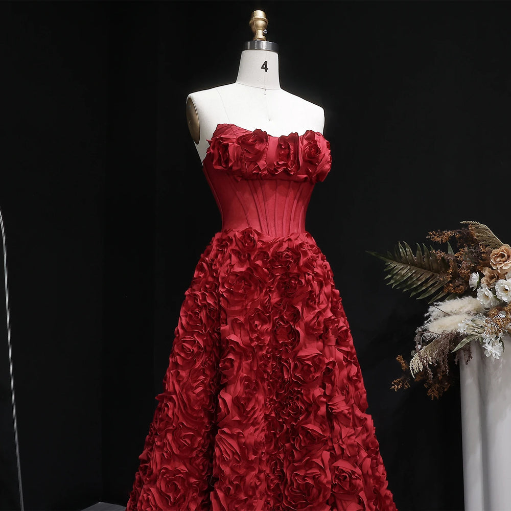 Red floral gown on a mannequin against a black background