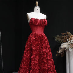 Red floral gown on a mannequin against a black background