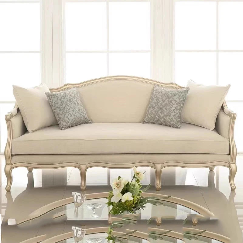 Beige classical sofa with carved birch wood frame in a sunlit luxury room