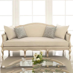 Beige classical sofa with carved birch wood frame in a sunlit luxury room