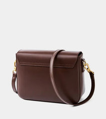 Brown leather handbag with a gold clasp on a light gray background