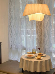 A stylish  Dining room illuminated by a cluster of designer fabric pendant lights. D