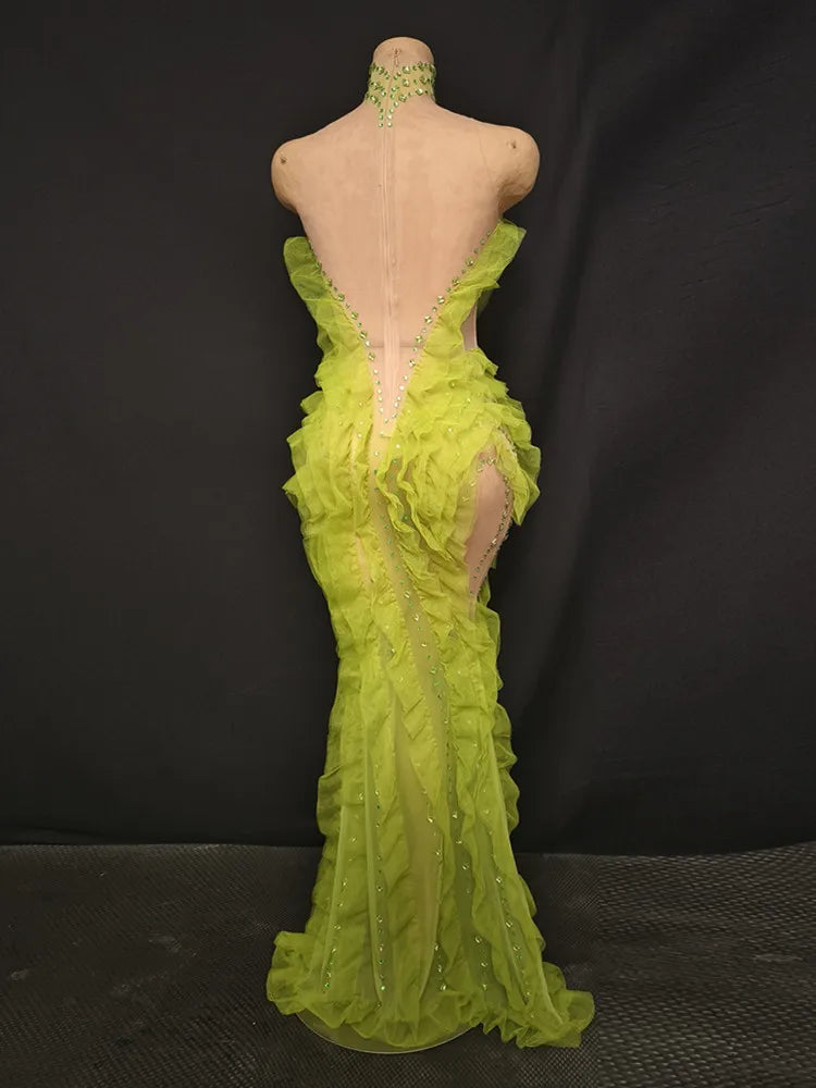 Green evening gown on a mannequin against a black background