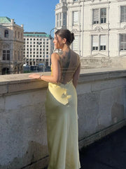 Woman in a light green dress standing on a rooftop with a cityscape background