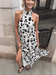 Woman wearing a black and white floral dress standing outdoors.