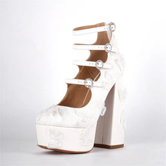 White high-heeled shoe with floral lace details on a light gray background