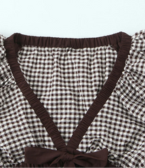 Brown and white checkered top with ruffled details on a white background