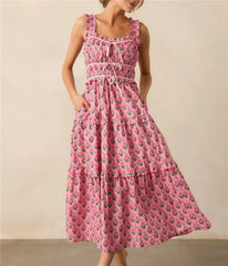 Woman wearing a pink dress with a floral pattern on a beige background