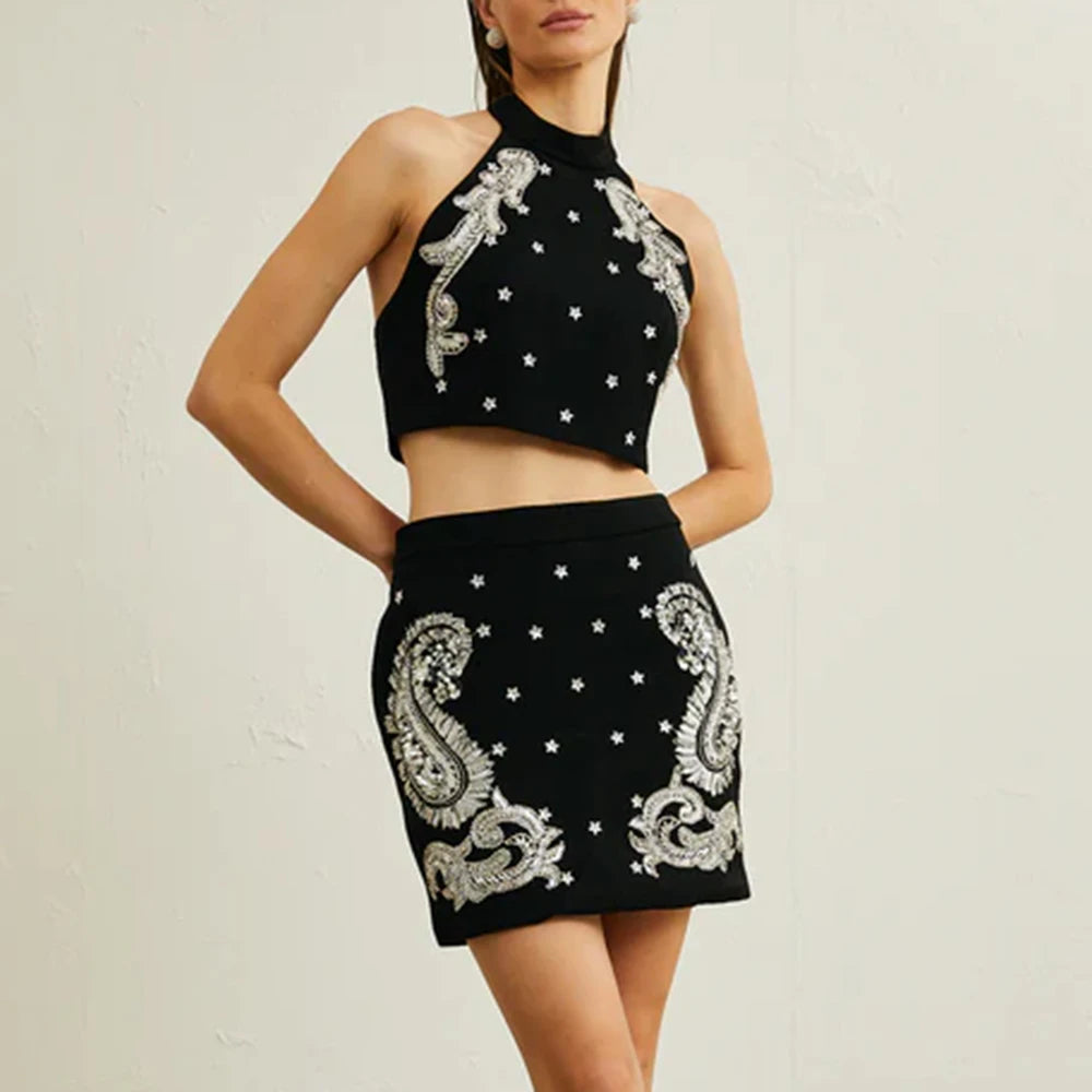Black crop top and skirt set with silver embroidery on a plain background