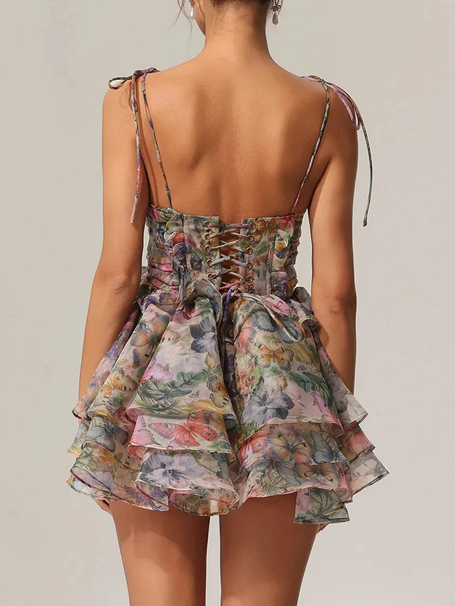 Floral tiered dress with thin straps on a plain background