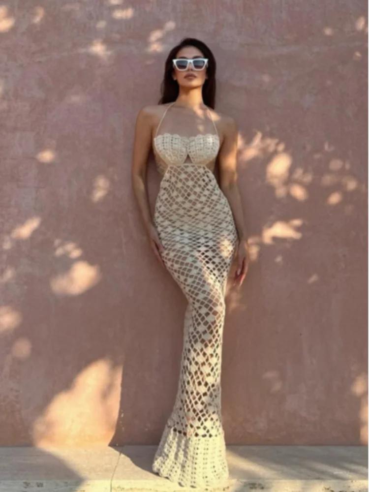 Woman wearing a patterned dress against a textured wall.