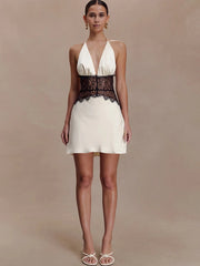 Full body shot of model wearing white halter neck mini dress